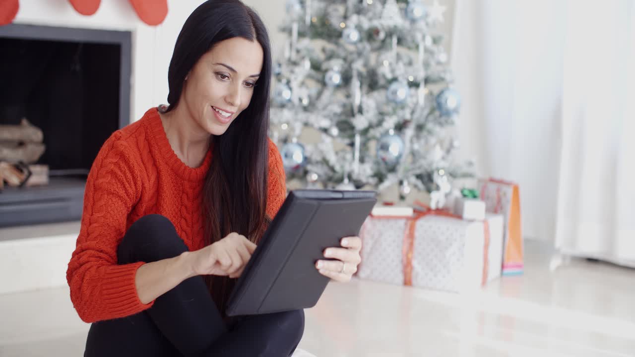 una mujer sonriente informándose en sus redes sociales.