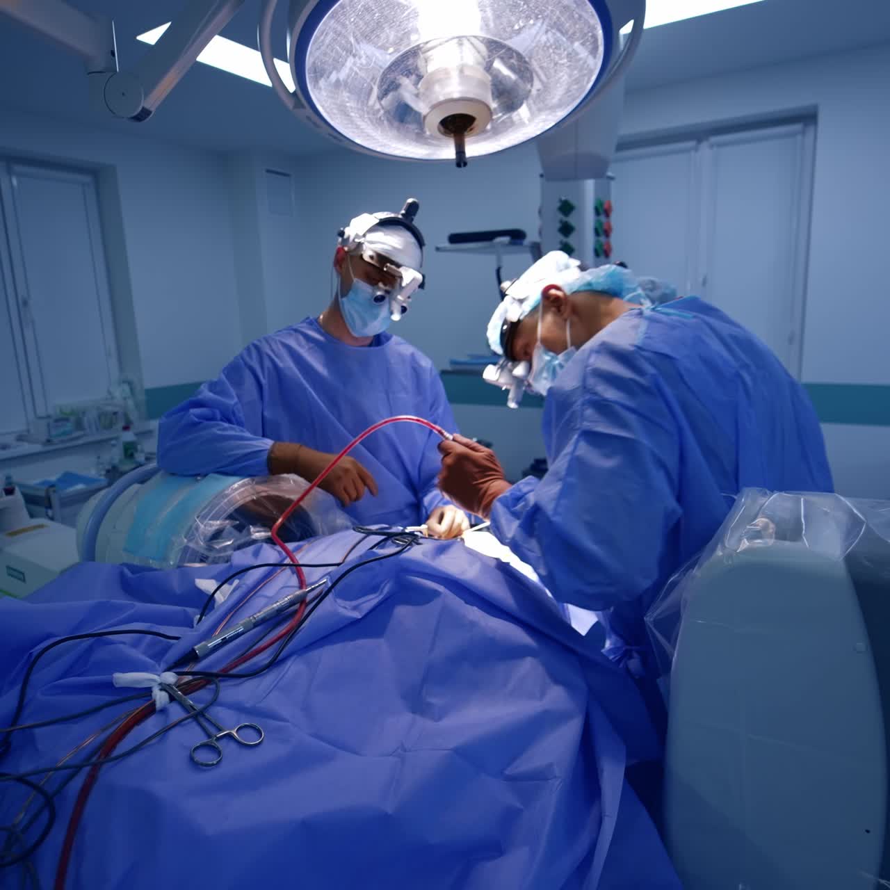Modern neurosurgical operation in technologically equipped surgery room. Two surgeons and assistant working at operational table