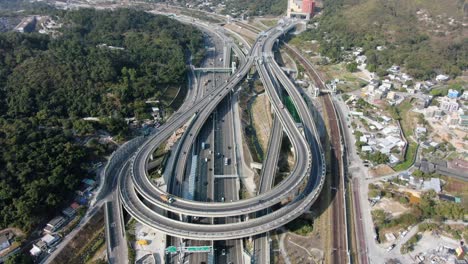 Verkehr-Auf-Einem-Massiven-Autobahnkreuz-Mit-Mehreren-Ebenen-Und-Schleifenförmiger-Straße-In-Hongkong,-Luftbild