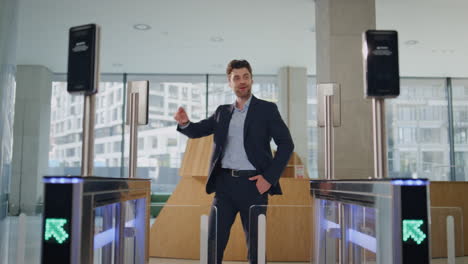 el hombre abre el torniquete automático de la puerta usando un reloj inteligente en un edificio de oficinas sonriendo.