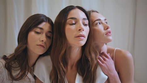 mujeres de apoyo abrazando juntos de cerca. modelos esperanzados parecen creer la cámara