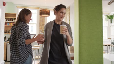 imágenes de video de 4k de una mujer de negocios saliendo de una reunión para tomar un café en la cocina de su oficina