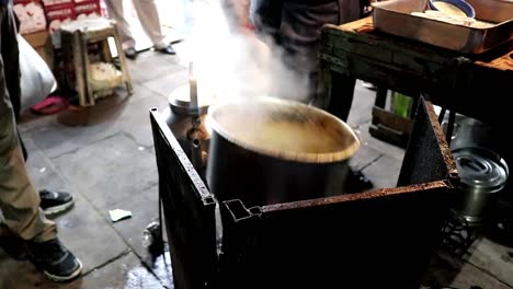 vendedor hirviendo el té chai en la vieja delhi