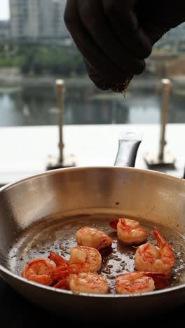 chef preparing shrimp in a pan