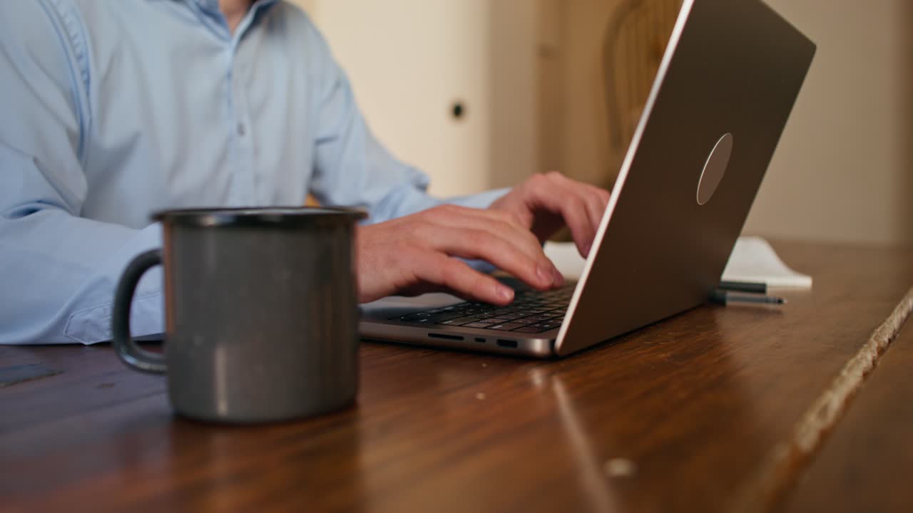 persona que trabaja en una computadora portátil en casa
