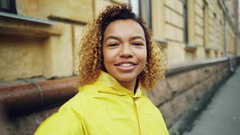 young woman in yellow raincoat, city selfie