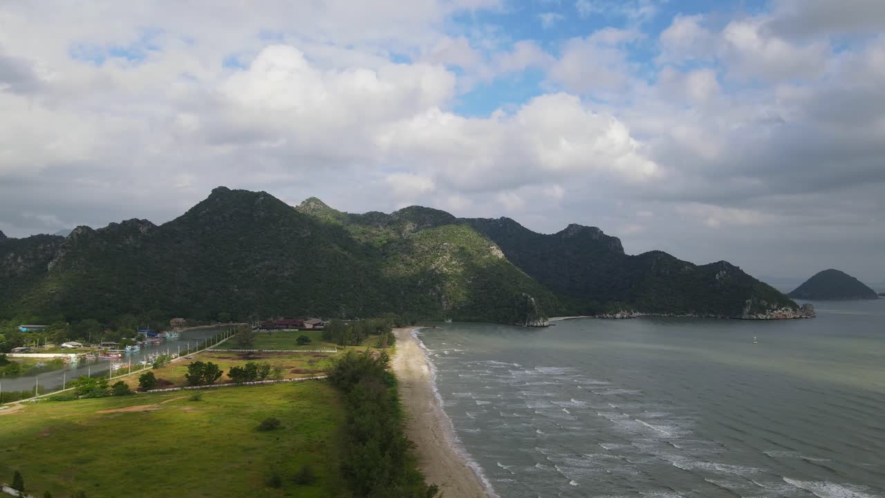 imágenes aéreas deslizándose hacia la izquierda revelando la luz del sol cayendo sobre la playa y el río estuarino con el pueblo de pescadores, parque nacional sam roi yot, prachuap khiri khan, tailandia