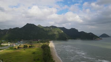 Imágenes-Aéreas-Deslizándose-Hacia-La-Izquierda-Revelando-La-Luz-Del-Sol-Cayendo-Sobre-La-Playa-Y-El-Río-Estuarino-Con-El-Pueblo-De-Pescadores,-Parque-Nacional-Sam-Roi-Yot,-Prachuap-Khiri-Khan,-Tailandia