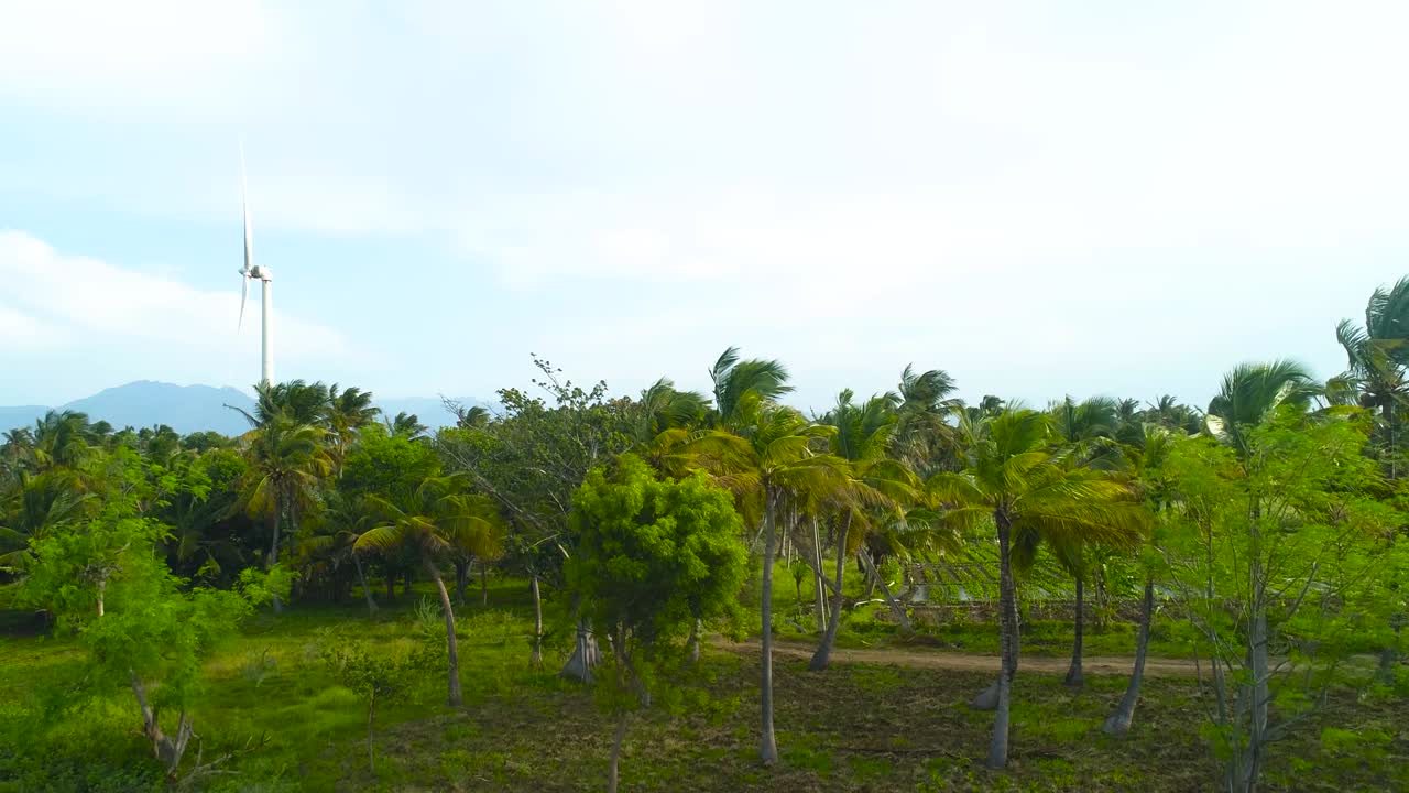 먼 배경의 산들과 함께 풍차 녹지가 있는 그림 같은 계곡에서 비행하는 드론 영상