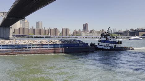 tugboat pushing new york trash barge filled to the brim