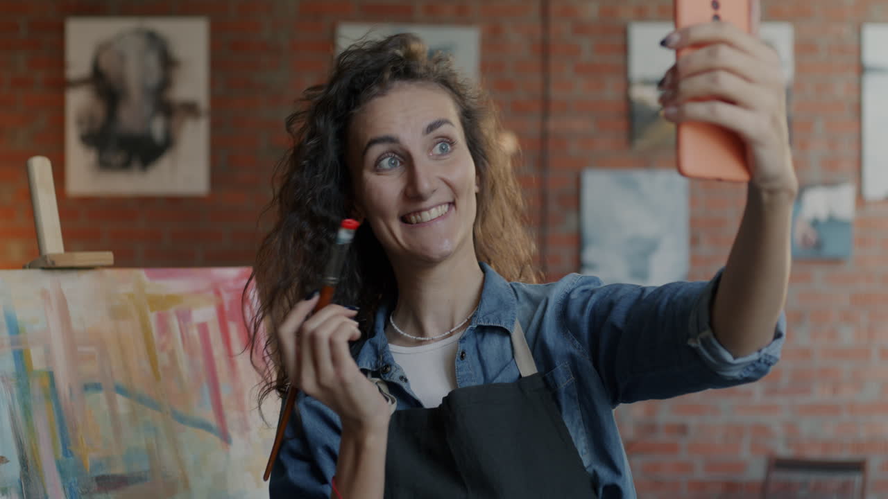 Artista felice che si fa un selfie nel suo studio