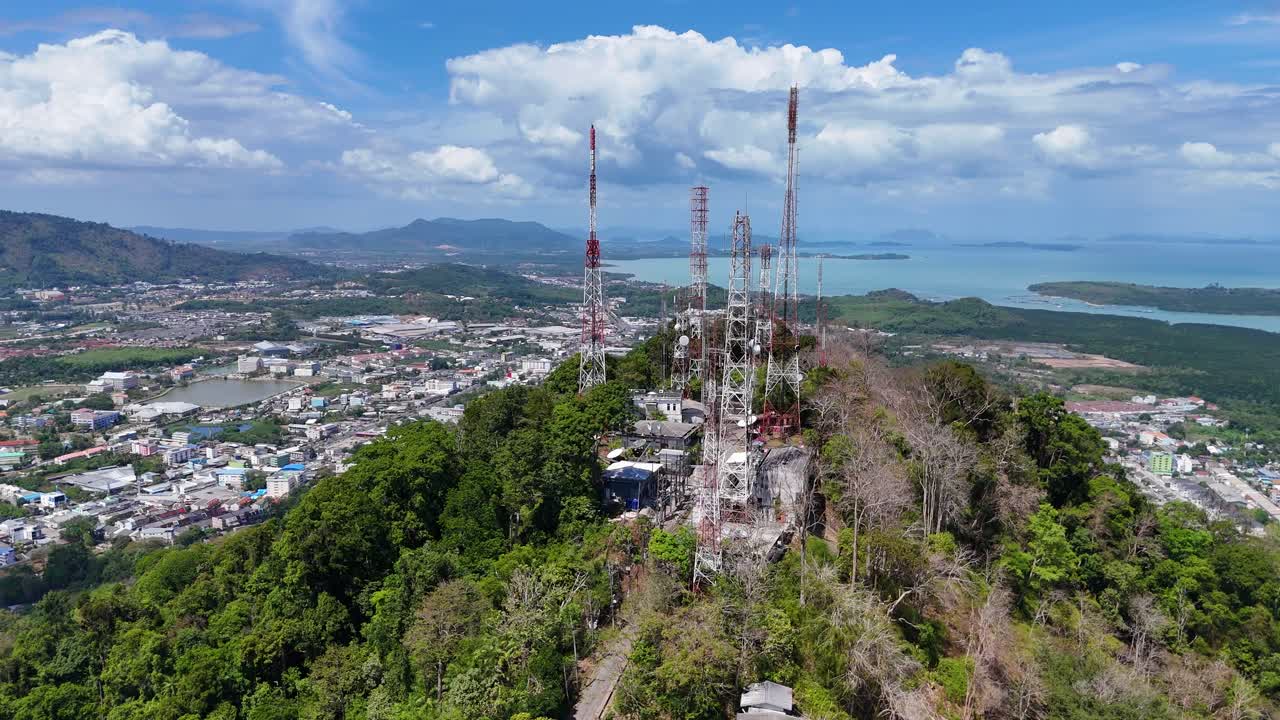 imágenes de drones capturan torres de telecomunicaciones en la cima de monkey hill en phuket, tailandia, con exuberante vegetación y vistas costeras bajo cielos despejados