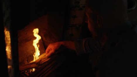 man putting wooden logs in fireplace at home 4k