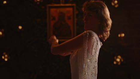 woman in a long white dress doing a modern dance and happily singing along in a church