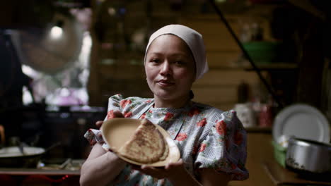 woman showing tortilla in a plate