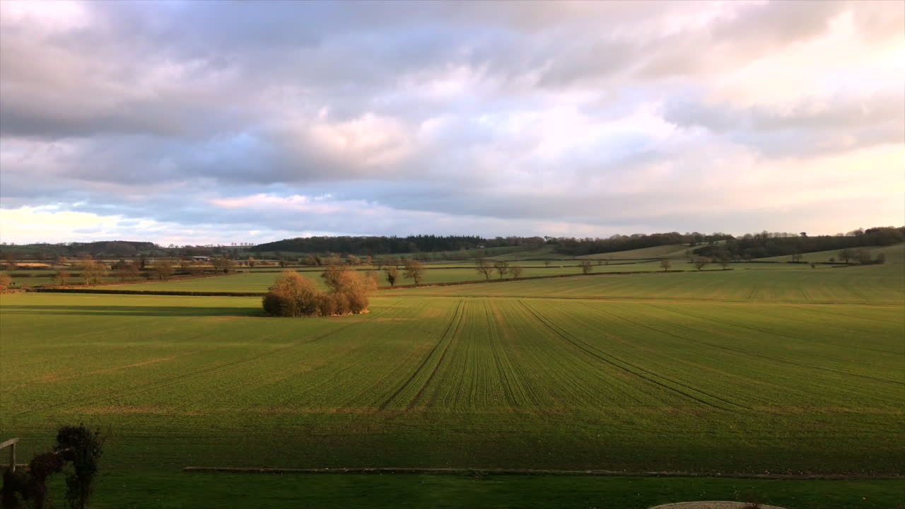 vista de la casa solariega de leicestershire sobre el campo con cielos azules y rosas y paddock verde durante el día