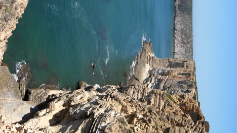 video vertical de acantilados escarpados y olas oceánicas en la costa de sagres, portugal