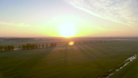 Heller-Bunter-Sonnenuntergang-Am-Horizont-Der-Landwirtschaftlichen-Landschaft-Lettlands---Luftrückzugsansicht