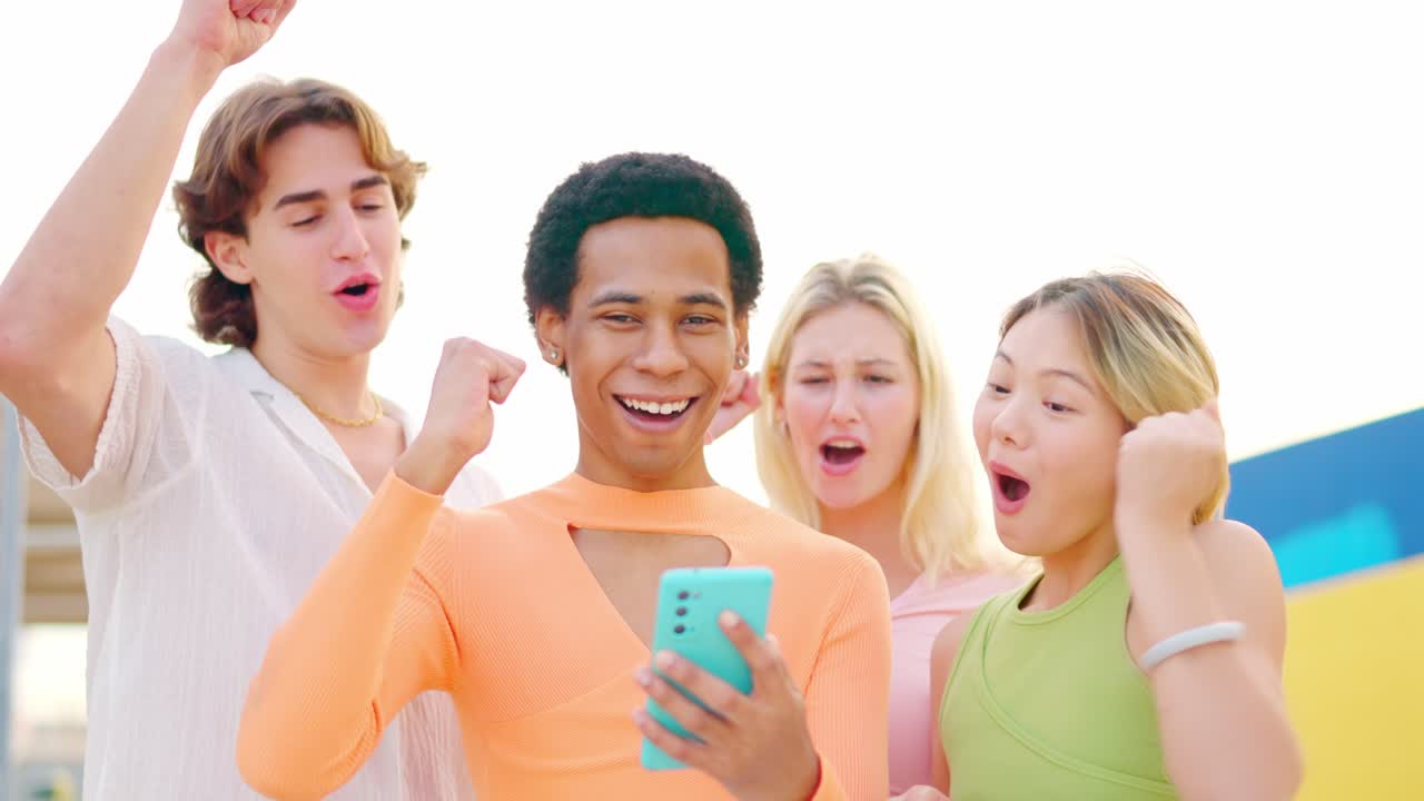 Group of friends celebrating while looking at a mobile phone