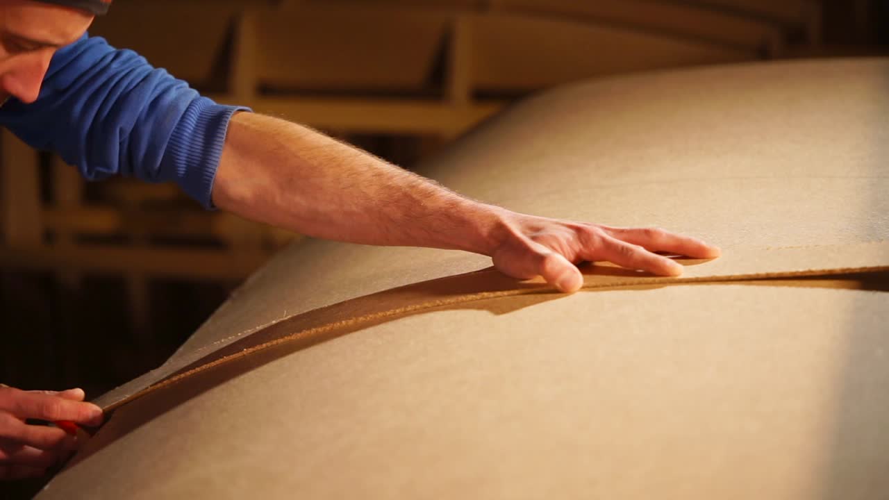 Falegname che segna un pannello di legno curvo