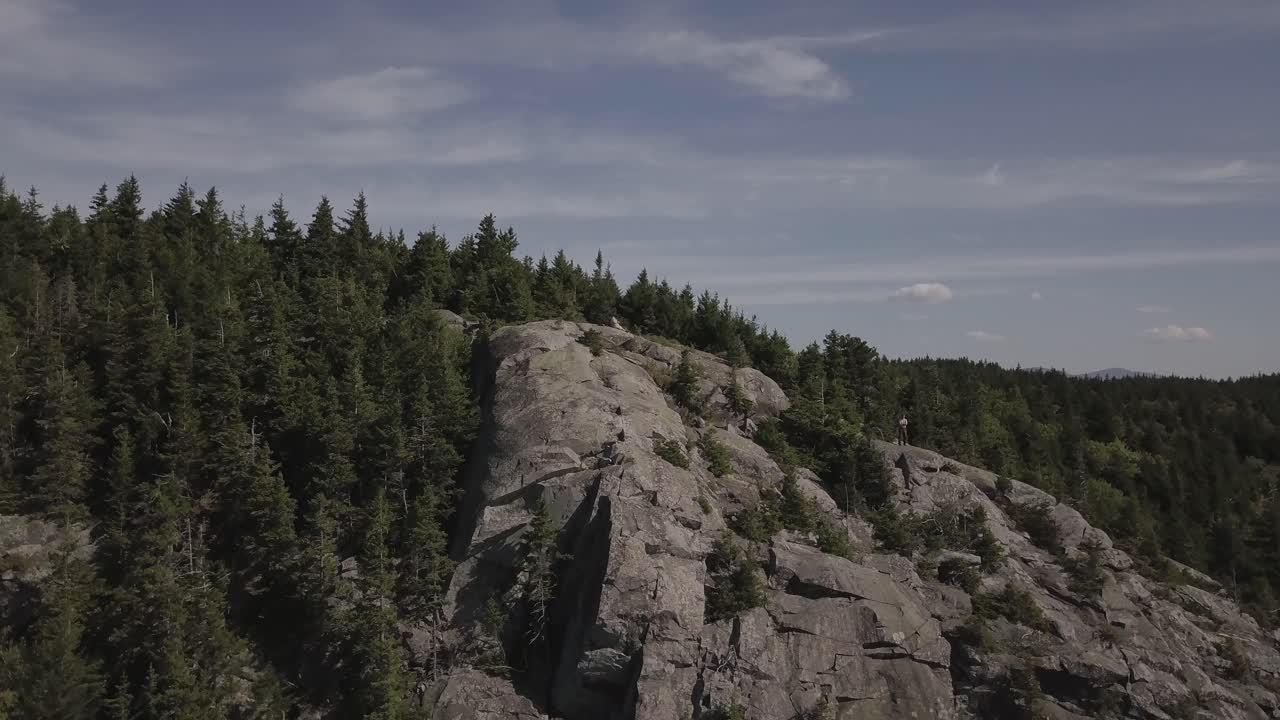 toma aérea de un dron volando sobre la línea de árboles de la cumbre de la montaña