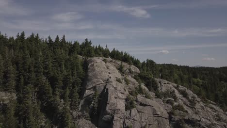 Aerial-Drone-Shot-Flying-Over-Mountain-Summit-Tree-Line