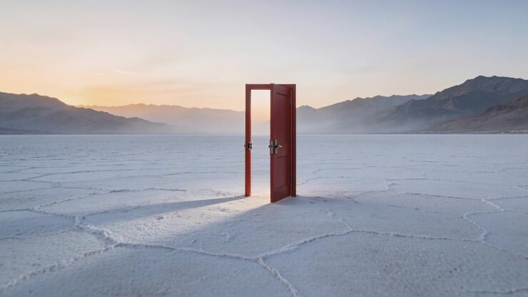 Swinging red door in rectangular frame slowly closing on cracked salt flat, low sun casting shadow