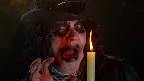 Finstere-Frau-Mit-Gruseligem-Halloween-Hexen-Make-up-Im-Kostüm,-Die-Voodoo-Zauberrituale-Mit-Kerze-Durchführt