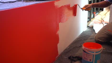 a painter painting a wooden stage wide view