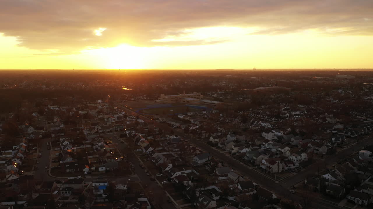 una vista aérea de gran ángulo sobre un barrio de long island durante un amanecer dorado