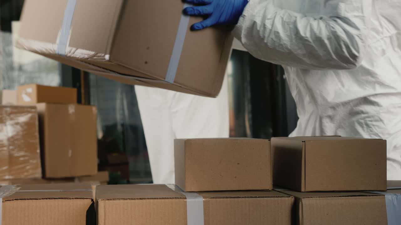 보호복을 입은 사람들이 상자가 있는 밴을 내립니다.