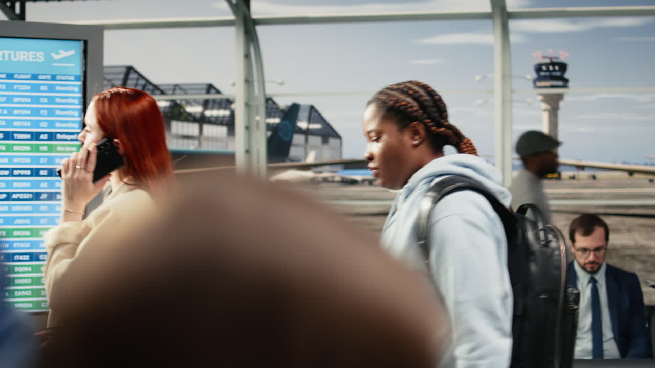 Mulher falando ao telefone percorre corredor de aeroporto lotado