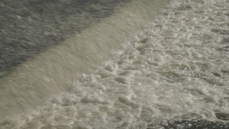 the fast splashing water stream of a weir