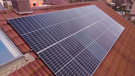 drone flying over set of solar panels installed on the roof of house with orange tiles