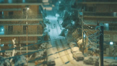 Town-neighborhood-road-at-a-frosty-winter-night-while-snowing