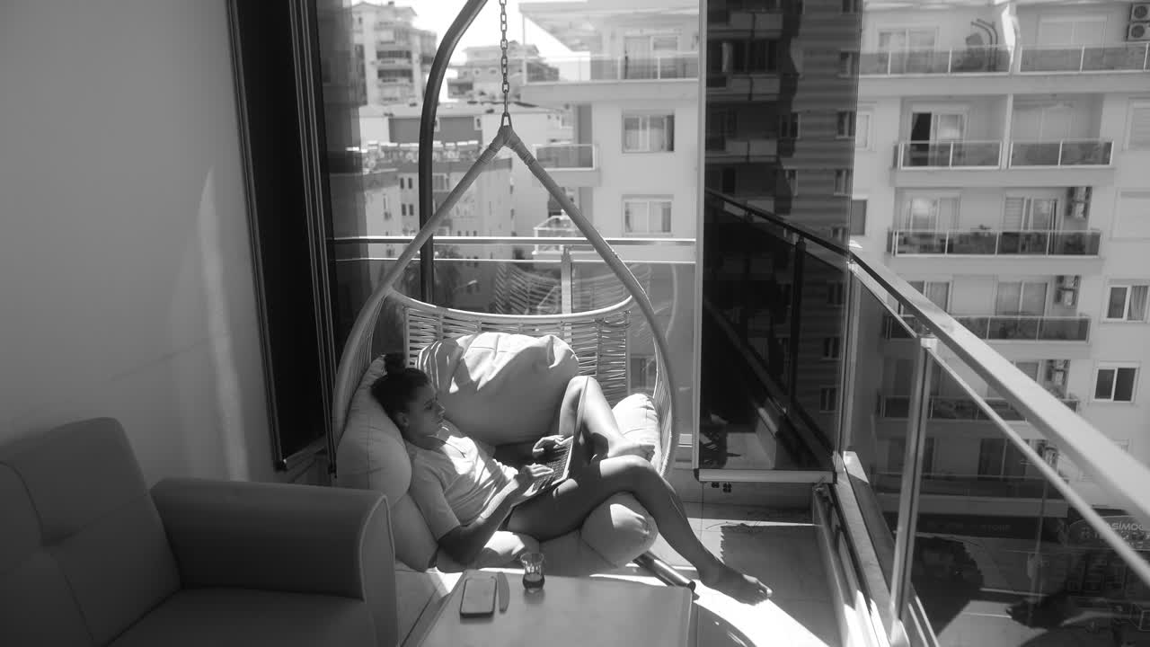 mujer trabajando en una computadora portátil en un balcón