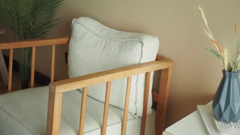 modern wooden armchair with light beige cushion in minimalist interior