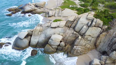 Aerial-Caribbean-Sea-rock-formation-by-coast-Bahia-Concha-Beach-Colombia