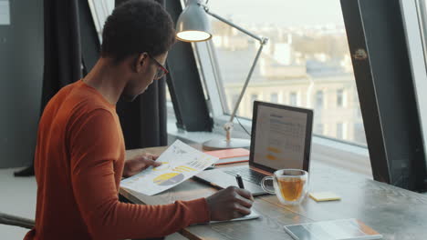 African-American-Man-Working-on-Business-Report-in-Office