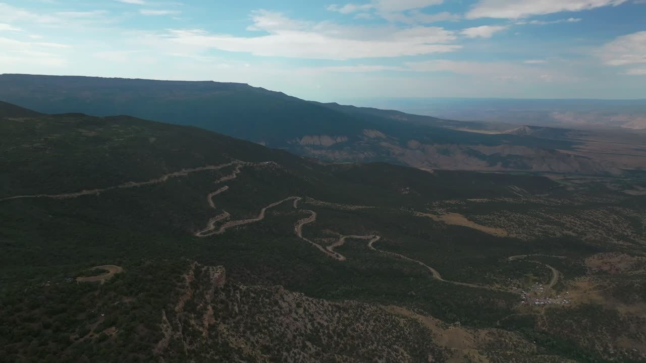 tierras final colina subida cuesta arriba pista de carreras tierra camino grand mesa grand junction colorado avión no tripulado mañana de verano nubes lluvia soleadas laderas occidentales delta montrose olathe sombra oscura hacia atrás movimiento hacia arriba