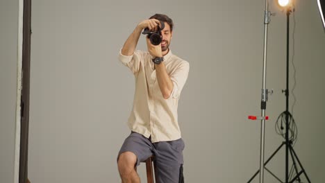 man smiling holding camera in studio