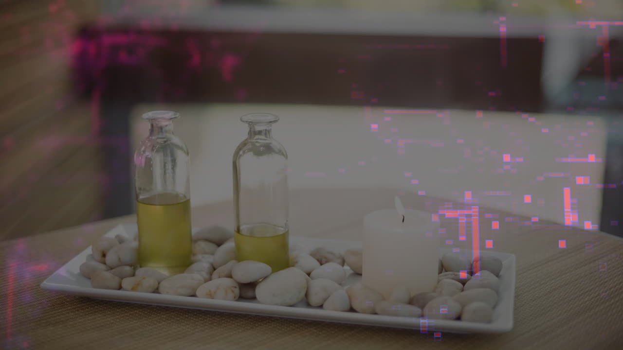 Spa tabletop showing ceramic tray holding pebbles, oil bottles and pillar candle on woven placemat