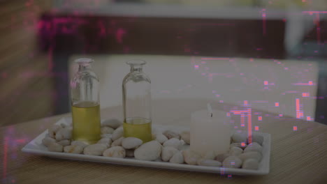 spa tabletop showing ceramic tray holding pebbles, oil bottles and pillar candle on woven placemat