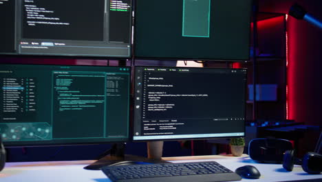 Close up of code running on computer displays in empty apartment used by hacker