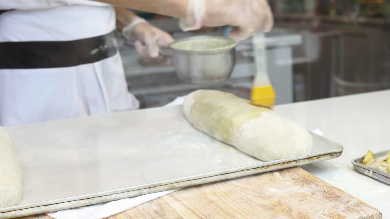 Baker Applying Glaze to Bread Loaves