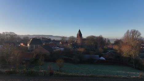 Aufsteigender-Drohnenschuss-In-Richtung-Des-Dorfes-Westouter-In-Westflandern-In-Belgien,-Das-Die-Kirche-Und-Das-Dorfzentrum-Zeigt