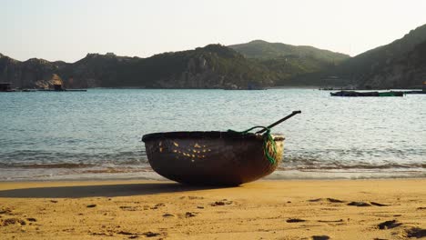 single traditional vietnamese coracle boat on sandy tropical beach