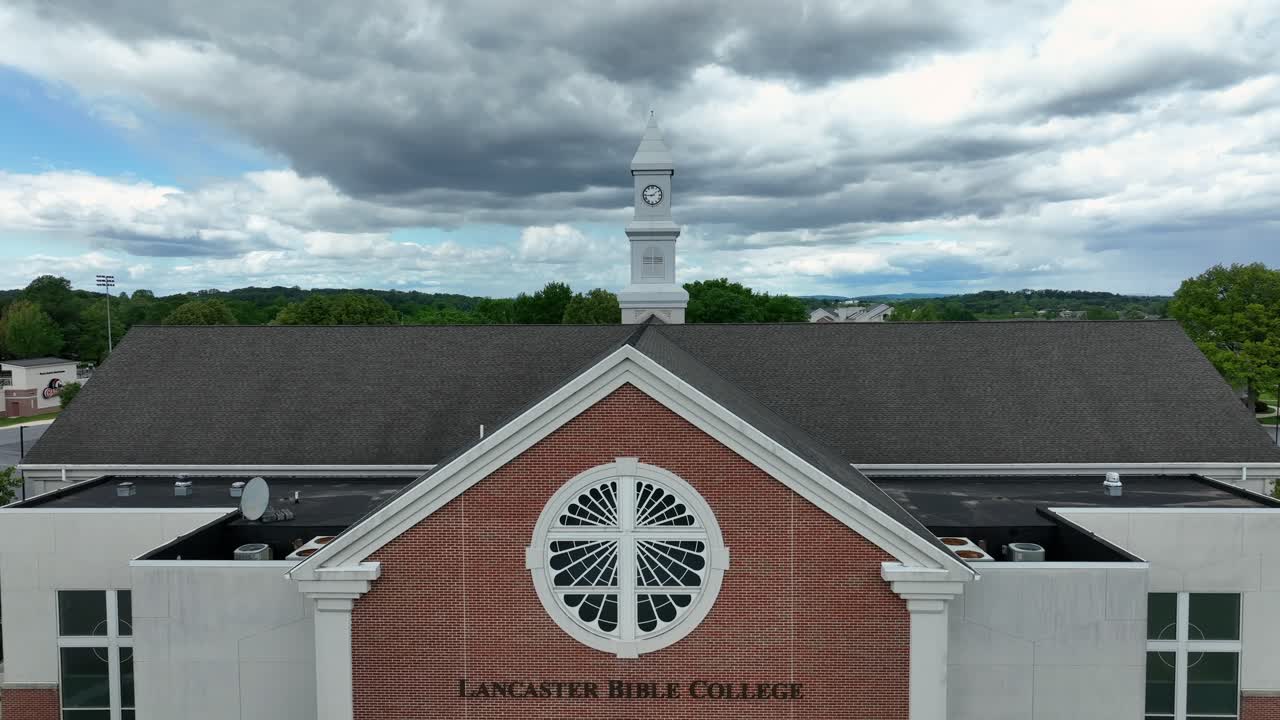 Aerial rising shot of red brick Lancaster bible college ok America. Sunny day with green trees. Pennsylvania, USA.