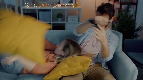 couple having a pillow fight at home