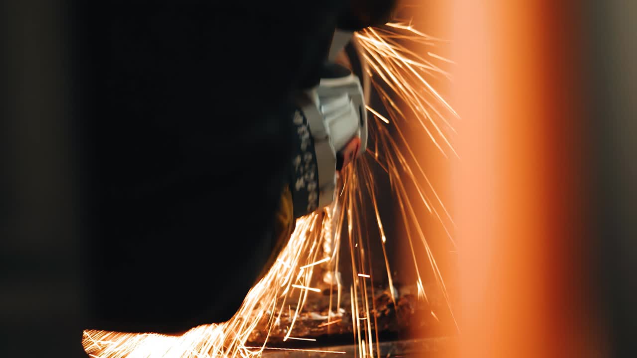 작업자가 용접 접합을 청소하는 데 사용하는 도구에서 불꽃이 날아갑니다. 근접 촬영